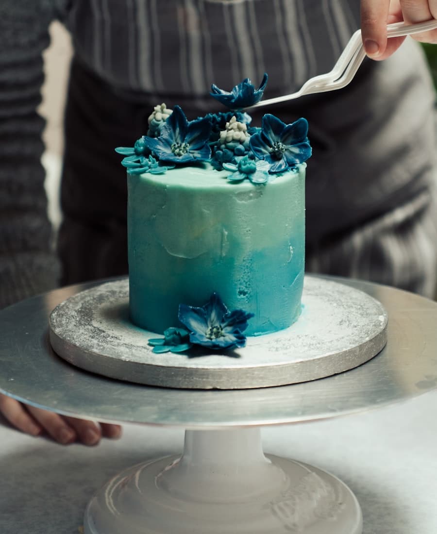 Placing buttercream flowers on a hand-piped cake